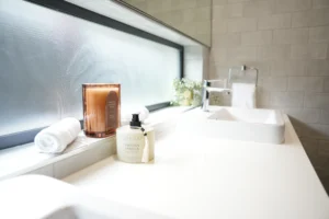 Bathroom vanity detail at Greenbank Oasis SafeStayz accommodation in Brisbane southside, with fresh towels, scented candle and quality hand soap provided for guests