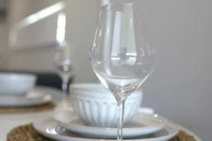 Place setting detail at Greenbank Oasis SafeStayz accommodation in Brisbane southside, with quality wine glass, ceramic dinnerware and woven placemat